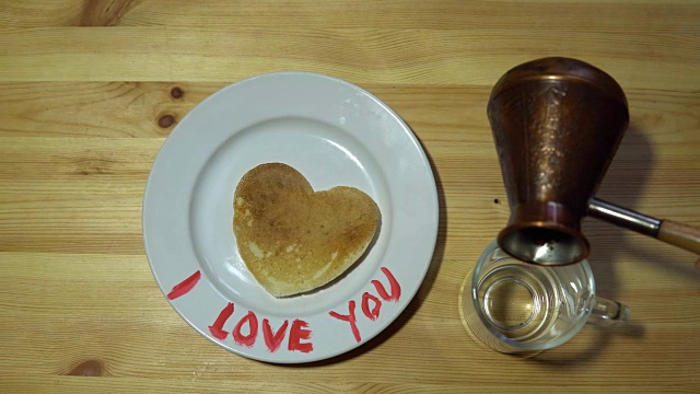 一个心形的盘子和一个放着咖啡的杯子。视频素材
