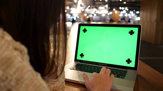 女人看着绿色屏幕的笔记本电脑视频下载