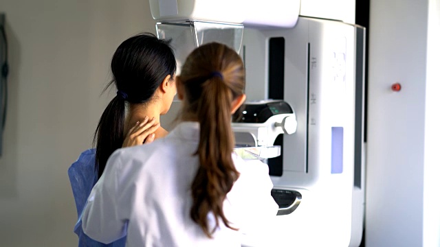 友善的医生正在给一位女性病人做乳房x光检查视频下载