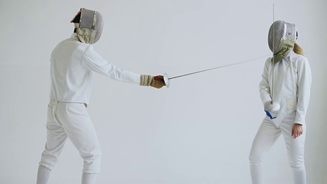 两名击剑运动员在白色背景下接受击剑训练视频素材