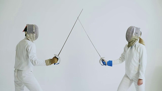 两名击剑运动员在白色背景下接受击剑训练视频素材