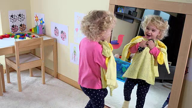 可爱的女孩与母亲在派对前通过镜子选择衣服视频素材