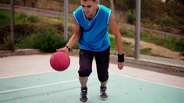 一个年轻人在外面练习篮球的特写。Slowmotion拍摄视频下载