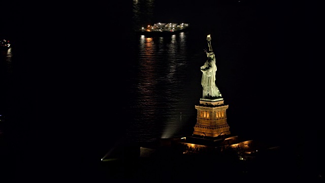 空中自由女神像在纽约港的夜晚闪闪发光视频素材