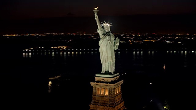 空中自由女神像在夜晚闪闪发光，背景是曼哈顿下城视频素材
