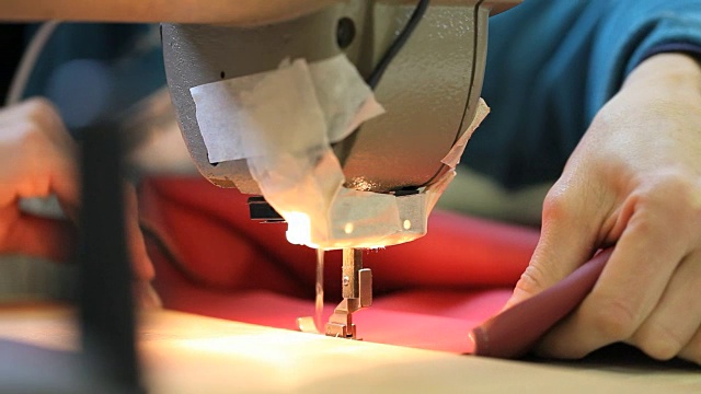 在缝纫机上缝制皮革的手工艺妇女的手视频素材