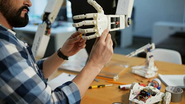 热心的构造师修理机器人的手的特写视频素材