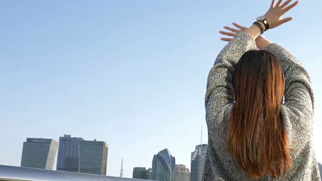 年轻的亚洲女人站在现代城市视频素材