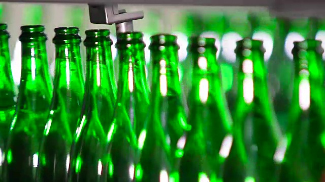 绿色的瓶子沿着传送带移动视频素材