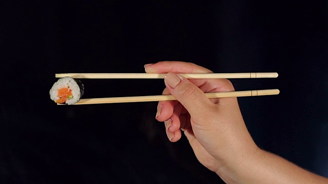 女手拿寿司寿司与筷子。视频素材