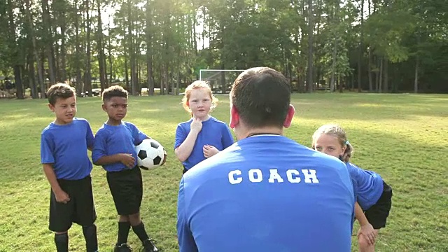 多民族儿童在足球队听教练讲课视频素材