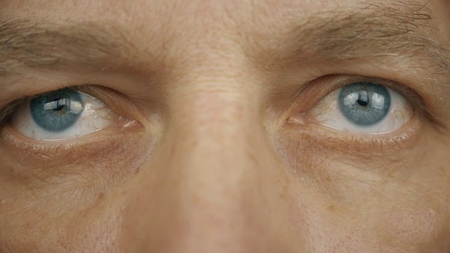 极端近的正面视图，男人的脸眼睛。蓝灰色的男性眼睛。男人的眼睛带着不同的情绪。微笑，认真，生气，想，读，看。视频下载