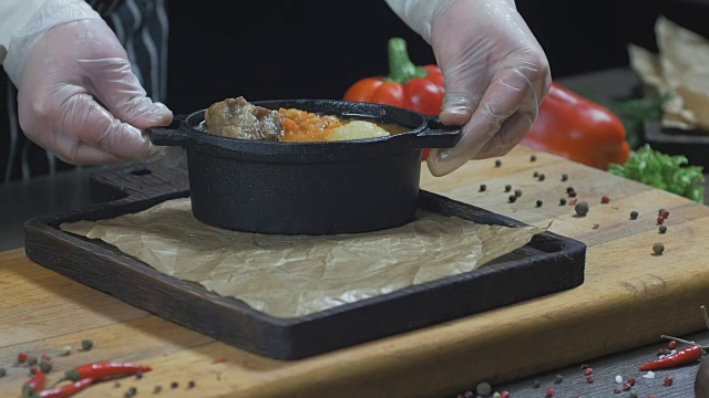 厨师正在用铁锅上肉汤。木板视频下载