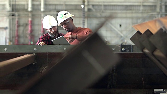 两名工人戴着安全帽，看起来像是平板电脑视频素材