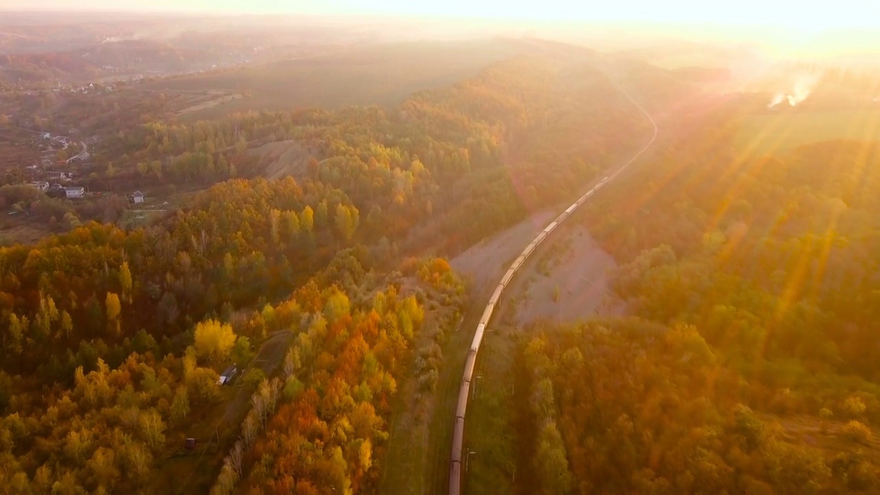 鸟瞰图:火车在树带在农村的景象在秋天。视频素材