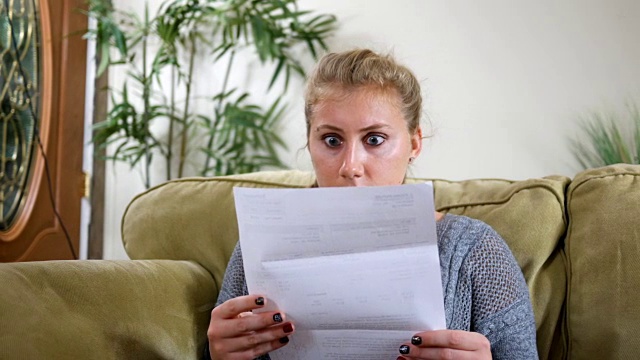 二十多岁的白人女性对邮件中的账单感到震惊视频下载