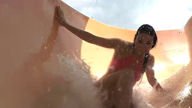 年轻女子滑下水上滑梯视频下载