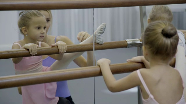 小女孩在芭蕾舞学校和老师一起做伸展运动视频素材