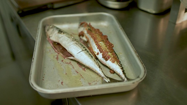 厨师将腌料涂在鱼上视频素材