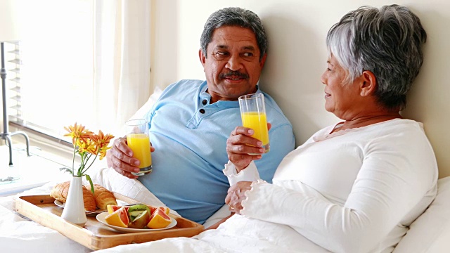 一对老年夫妇在卧室吃早餐视频素材