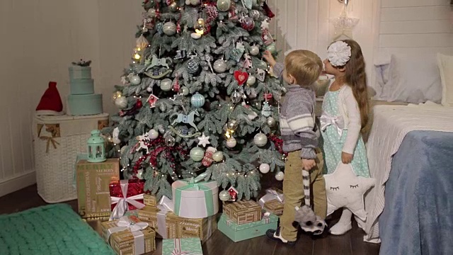 两个小孩装饰圣诞树。视频素材