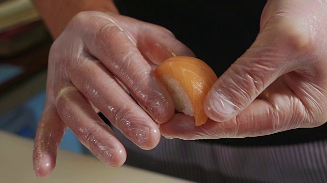 大厨的手在做寿司的微距镜头。视频素材