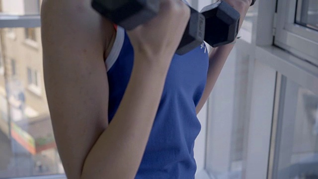 这位女运动员用杠铃式前卷来锻炼她的二头肌视频素材