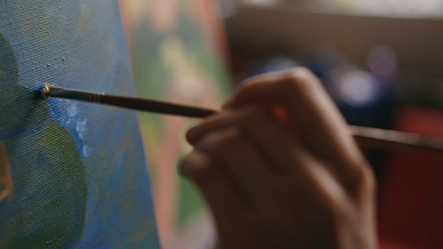 特写的艺术家女人的手与画笔在帆布上画静物画在艺术工作室视频素材