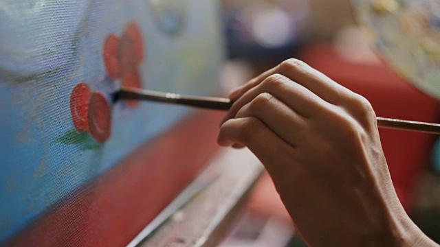 特写的艺术家女人的手与画笔在帆布上画静物画在艺术工作室视频素材