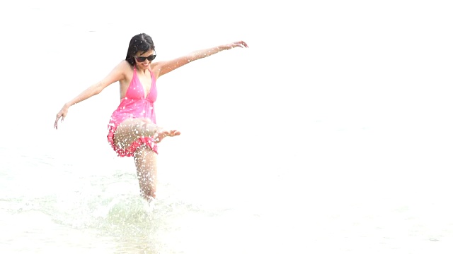 迷人的女人喜欢在海滩上穿粉红色的比基尼套装视频素材
