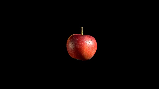 特写旋转新鲜的红苹果在黑色的背景。视频素材