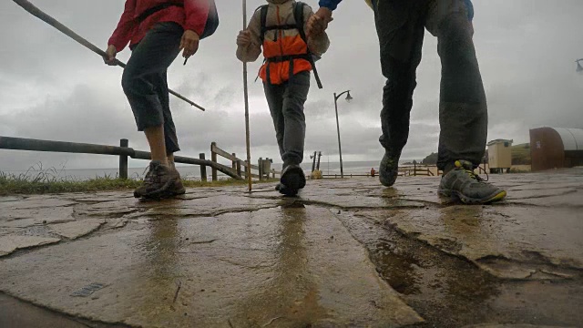 父亲，母亲和小儿子一起走在著名的圣地亚哥之路或“圣詹姆斯之路”的雨天。视频素材