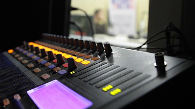 专业音频操作员在电视直播期间对音频混音旋钮进行操作。视频素材