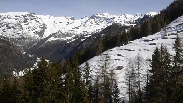 冬季无人机建立雪山下的森林森林山谷。雪山在户外自然。向前飞行。旅行探索阿尔卑斯山，4k俯视图视频视频素材