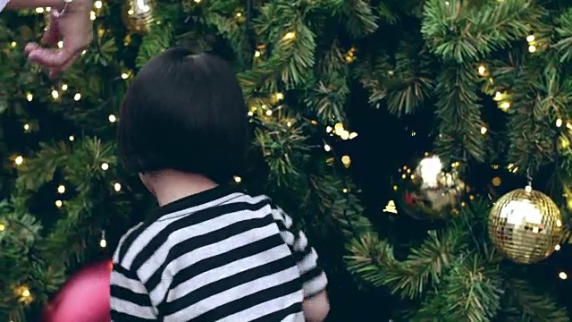 年轻的母亲和婴儿女孩享受在圣诞节的节日视频素材