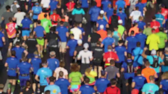 城市马拉松赛事鸟瞰。一群跑步运动员。人们的t恤。街道上挤满了参加大众赛跑的选手视频下载