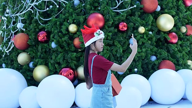 年轻女子在圣诞节期间用手机自拍视频下载