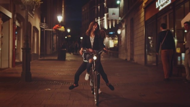 女孩们在晚上骑自行车视频素材
