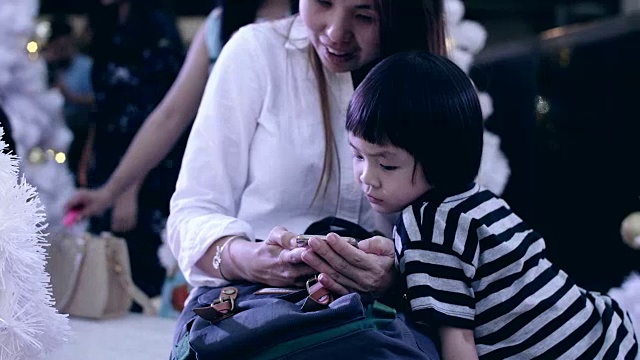 年轻的母亲和女婴使用智能手机和享受在圣诞节视频下载