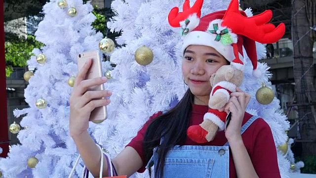 年轻女子在圣诞节期间用手机自拍视频下载