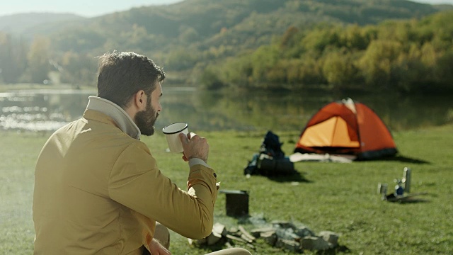 在湖边喝咖啡的男人视频素材