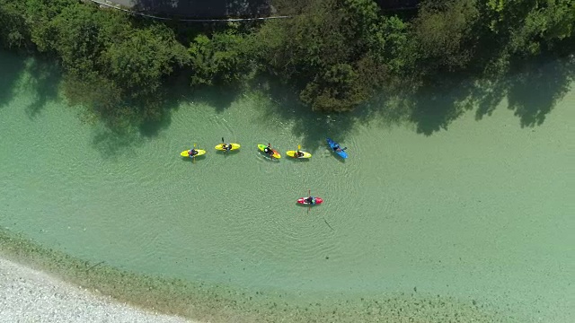 空中俯瞰:一群皮划艇选手滑下清澈的翡翠溪流视频素材