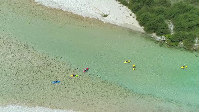 航拍:夏天，一群皮划艇爱好者在一条美丽的翡翠河上划皮划艇视频素材