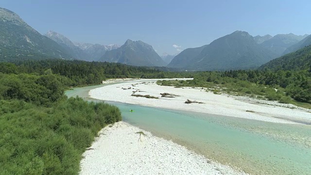 几名皮划艇运动员在美丽的绿色河流上滑行穿过山谷视频素材