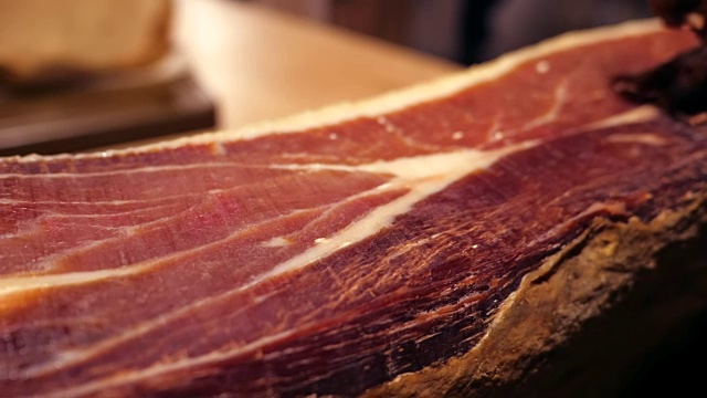 Jamon塞拉诺。传统西班牙火腿在市场上收市。桌上的猪腿火腿。餐厅内部的美食肉。整个火腿放在架子上。多莉视频下载