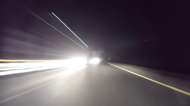 POV时间推移，快速的汽车在晚上行驶在古老的乡村道路上。迎面而来的卡车。在高速公路上行驶在古老的道路上。摄像机被放置在汽车外面，水平是水平的，给人一种穿越无尽系列的幻觉视频下载