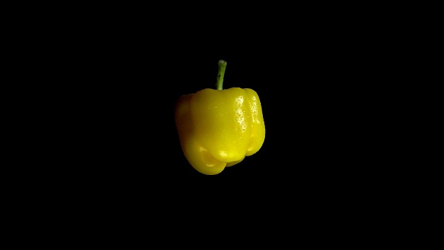特写旋转新鲜的黄色胡椒在黑色的背景。视频素材