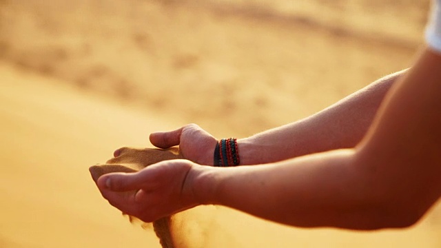 双手在沙漠中拾起沙子视频素材