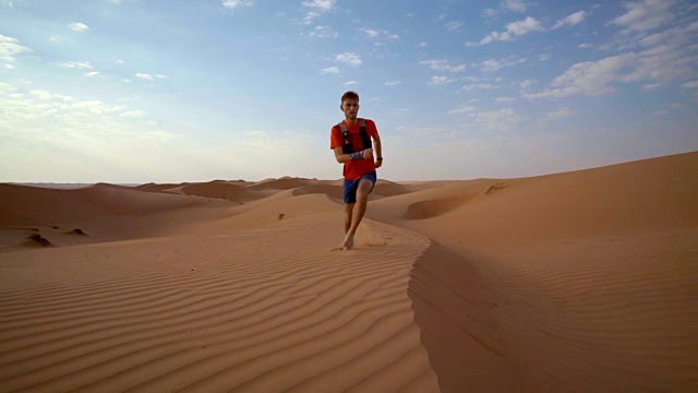 登山运动员攀登沙漠中的沙丘视频素材