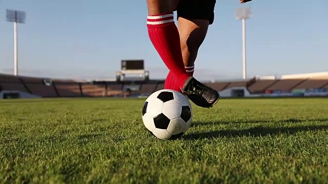 足球运动员用慢动作展示步法和足球运动员在球门上踢球和射门视频素材